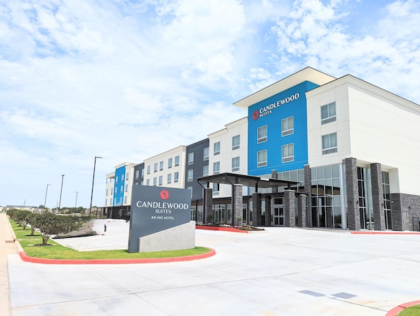 A modern hotel with a blue and white exterior, a covered entrance, and a landscaped area with a sign indicating it is Candlewood Suites. - Candlewood Suites Tulsa Hills Jenks (Tulsa)