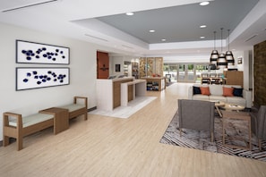 A modern hotel lobby with a reception desk, seating area, and artwork on the walls. - Candlewood Suites Tulsa Hills Jenks (Tulsa)