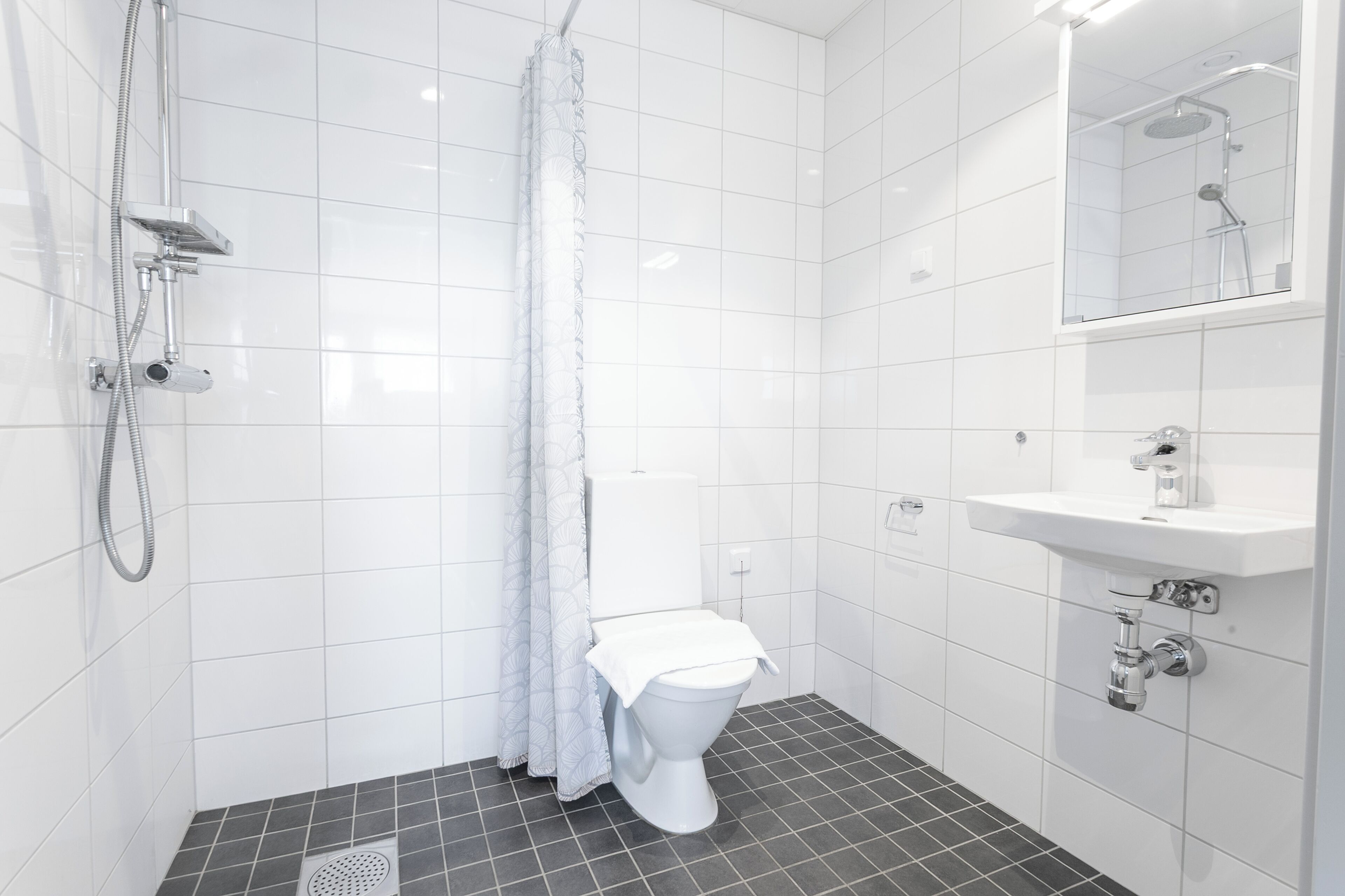 Un bagno moderno con doccia, WC e lavandino.
