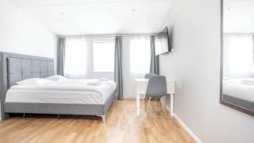 Quarto de hotel moderno com cama, escrivaninha e cadeira.
