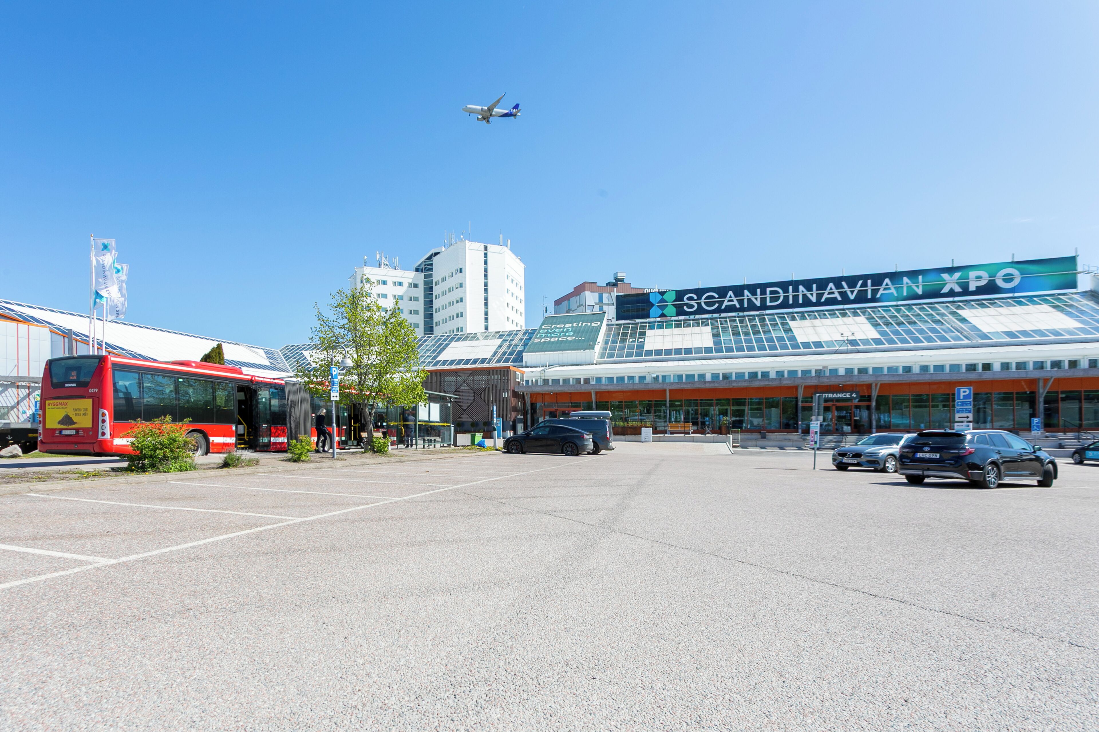 A spacious parking lot with a modern building labeled "Scandinavian XPO" in the background.