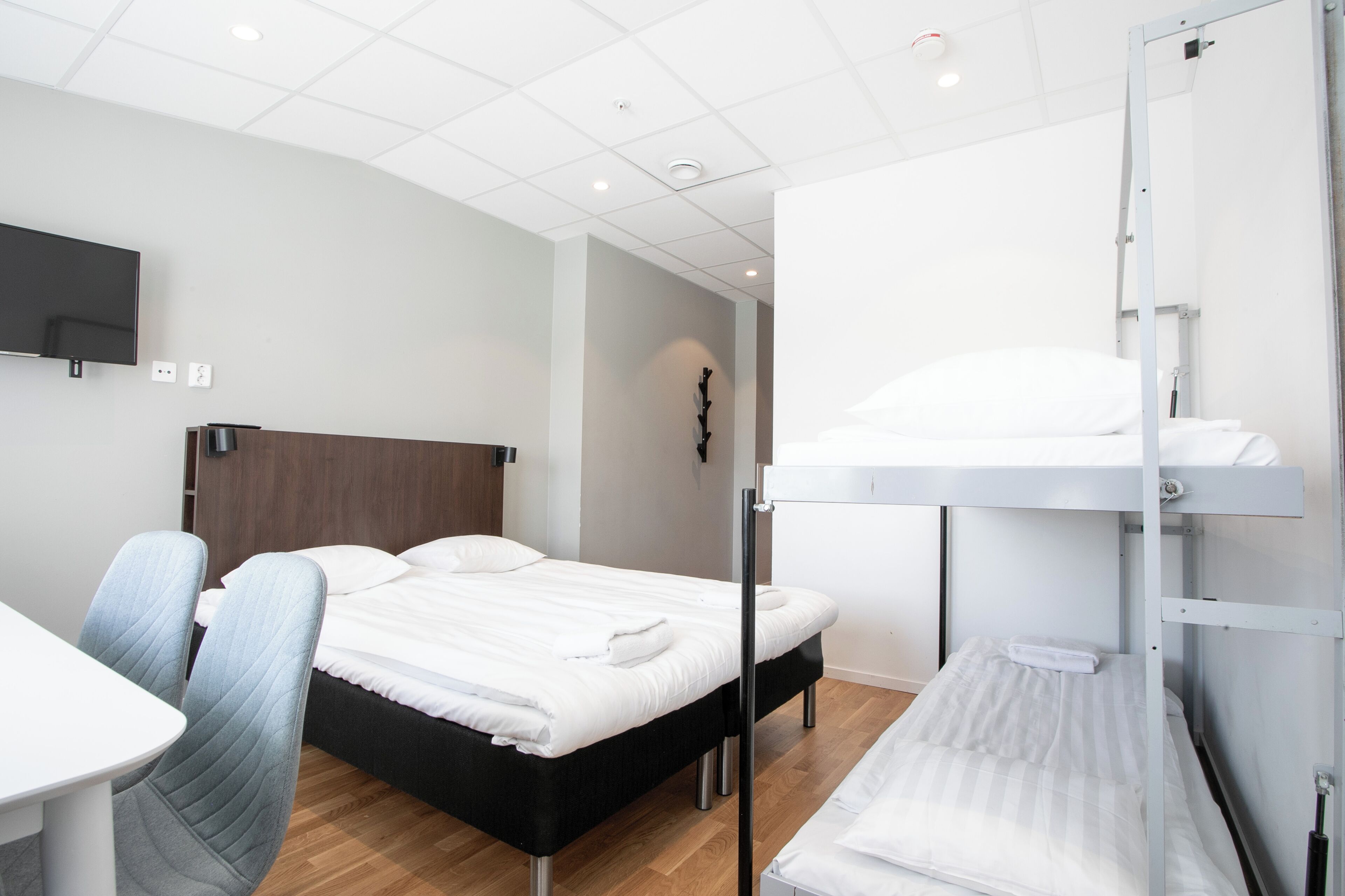 Ein Hotelzimmer mit Etagenbett, Schreibtisch und Stuhl.