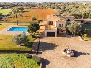 A large house with a swimming pool, a garage, and a well-maintained garden.