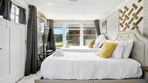 Habitación de hotel con dos camas, un ventanal grande y vistas al exterior.