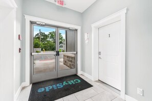 Enter through the double glass door to a covered area with a view of the outside.