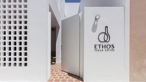 A white building with a sign reading "ETHOS VECAN SUITES". - Ethos Vegan Suites (Santorini)