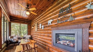 A log cabin interior with a fireplace, wooden furniture, and a ceiling fan. - 4BR / 4 1/2 BA,  Covered deck with Hot-tub overlooking the mountains (Maggie Valley)