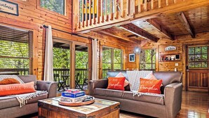 A cabin interior with two sofas, a wooden coffee table, and a sign reading "WELCOME CABIN". - PROMO 10% WEEKLY DISCOUNT September Special,Hot tub Pool table, Arcades WIFI-Pet (Sevierville)