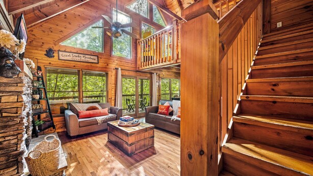 A spacious cabin with a loft bedroom, a cozy living area with a fireplace, and large windows offering a view of the surrounding forest. - PROMO 10% WEEKLY DISCOUNT September Special,Hot tub Pool table, Arcades WIFI-Pet (Sevierville)