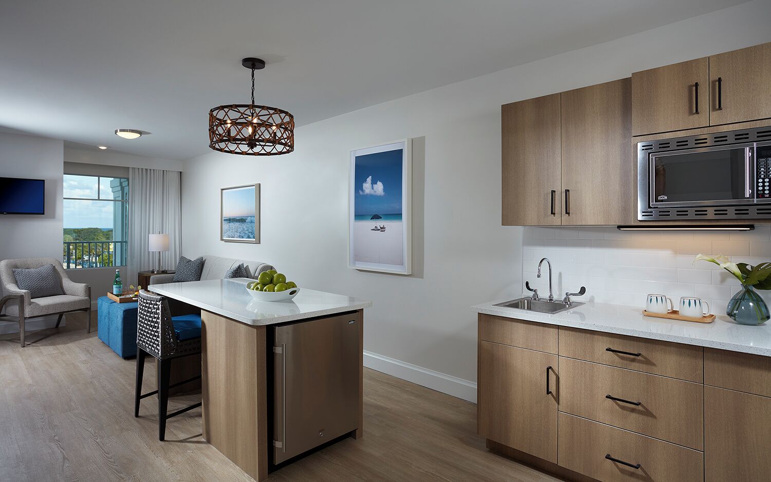 A modern kitchen with a built-in microwave, a sink, and a bar area with seating.
