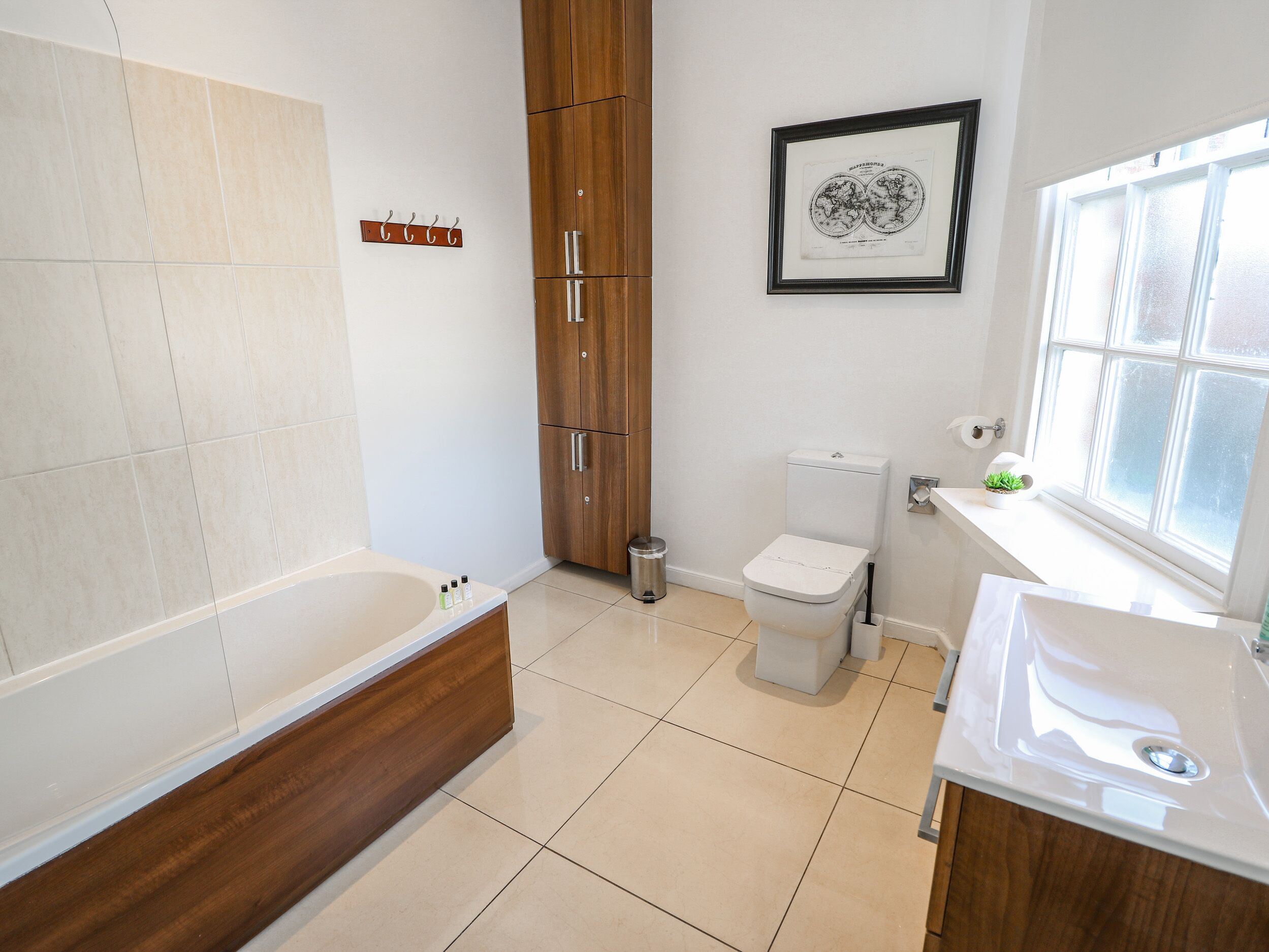 A modern bathroom with a bathtub, toilet, and sink.