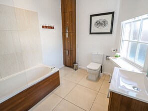 Une salle de bain moderne équipée d’une baignoire, de toilettes et d’un lavabo.