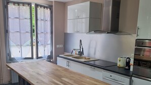 Una cocina moderna con encimera de madera, electrodomésticos de acero inoxidable y vistas al exterior.