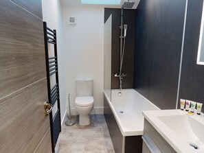 Un baño moderno con inodoro, ducha y lavamanos.