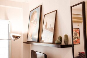 A wall with framed pictures, a mirror, and a shelf with decorative items. - Beautiful, renovated apartment in Alameda by RentalSevilla (Sevilla)