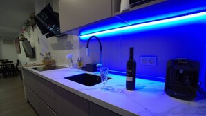 Una cocina moderna con encimera de mármol, un lavamanos empotrado y una cafetera Bosch.