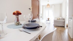 Een eettafel gedekt met borden, glazen en een vaas met bloemen.