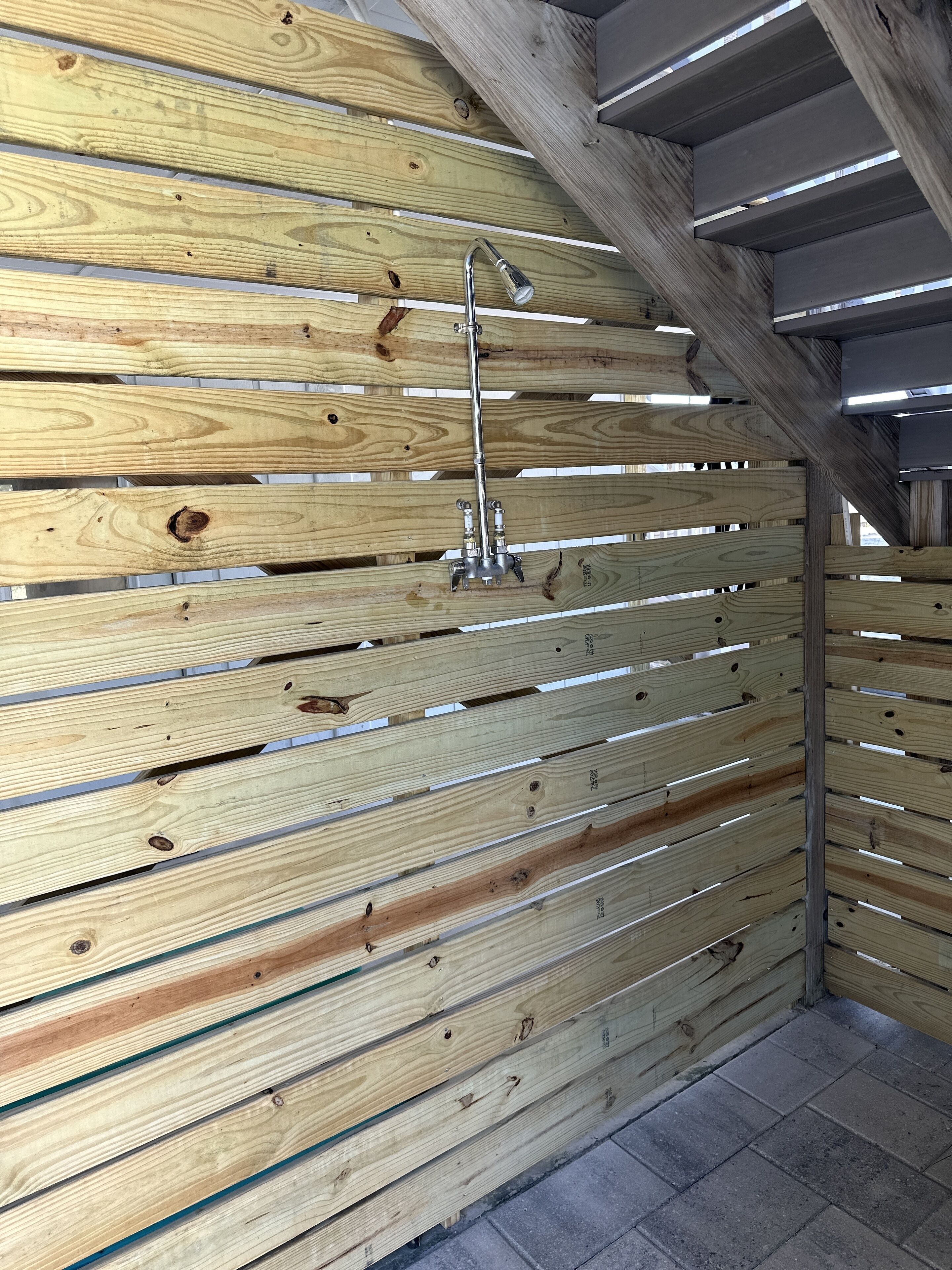 Un mur fait de lattes de bois, avec un robinet en métal.