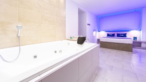 Une salle de bain moderne dotée d’une grande baignoire, d’une douche et d’un espace douche séparé.
