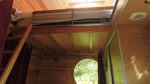 Ein gemütlicher Raum mit Oberlicht, kleinem Fenster und Etagenbett.