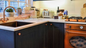 A kitchen with a sink, toaster, stove, and cabinets.