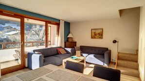 A living room with a sofa, armchair, coffee table, and a painting on the wall. - APARTMENT WITH POOL ACCESS - ST JEAN D'AULPS RESORT - 6 Pers / 60m² - Riam D2 (Saint-Jean-d´Aulps)