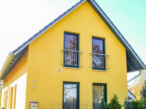 A yellow building with two windows and a balcony, labeled '6d 6c'.