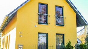 A yellow building with two windows and a balcony, labeled '6d 6c'. - Vacation home Bodden - semi-detached house (Saal)