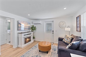 Cozy seating area with a fireplace, flat-screen TV, and comfortable sofa.