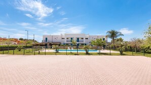 A modern building with a swimming pool, surrounded by a paved area and greenery. - Appartamento Cristallo by BarbarHouse (Boncore)