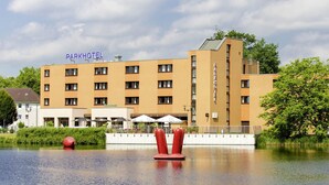 Ein Hotel im modernen Design mit einem zentralen Innenhof, der ein Wasserelement und rote Skulpturen zeigt.