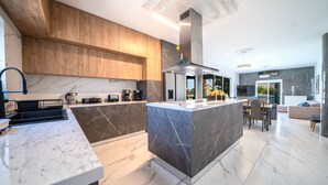 Una cucina moderna con piani in marmo, pensili in legno e un'isola centrale.