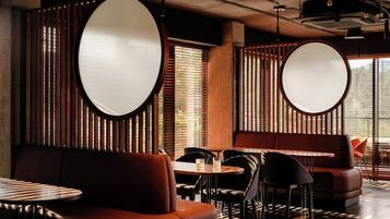 A restaurant interior with round tables, booths, and a modern design.