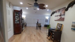 A spacious living area with hardwood flooring, a ceiling fan, and a dining table with chairs. - Remodeled one story pool home, hiking trails, lake, beach & more.. (Agoura Hills)