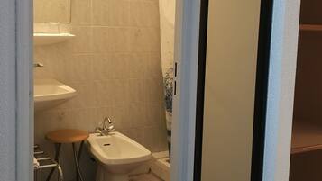 Une salle de bain avec un lavabo, un bidet et un miroir.