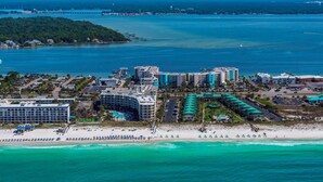 Vista aérea de un resort costero con varios edificios, una playa y un puerto deportivo.