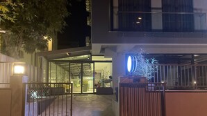 Un edificio moderno con ingresso in vetro, cancello in metallo e interni ben illuminati.