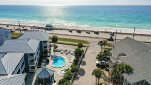 A hotel with a swimming pool, beach view, and parking area. - Miramar Beach Condo: Pool, Hot Tub, Beach (Miramar Beach)