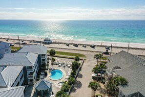 A hotel with a swimming pool, beach view, and parking area. - Miramar Beach Condo: Pool, Hot Tub, Beach (Miramar Beach)