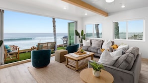 A spacious living area with a view of the ocean, a ceiling fan, and a large window. - Prime Waterfront Retreat P807-2 (Oceanside)