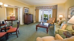 A hotel room with a dining area, a sofa set, a coffee table, and a view of the outdoors. - Luxurious 2 bedroom, 2 bath Oceanfront Condo @ the Ritz Carlton Club (St Thomas)