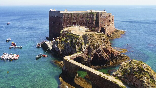 A historic stone fortress by the sea with a clear view of the ocean and boats. - DaLagoa Charm Villa Pool Beach (VAU)