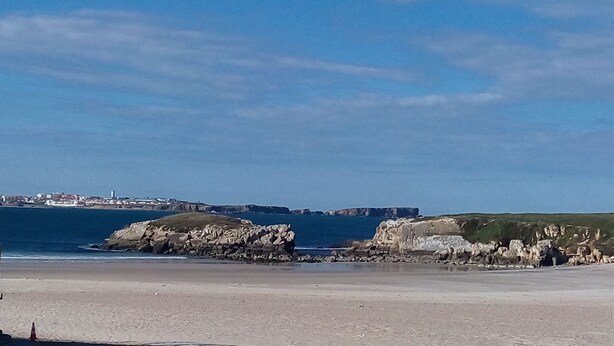 Un paisaje costero con acantilados rocosos y una playa.