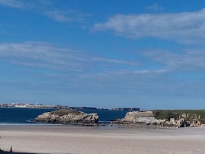A coastal landscape with rocky cliffs and a beach.
