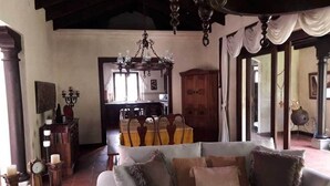 A living room with a sofa, a chandelier, and a wooden cabinet. - Casa Antigua (Antigua Guatemala)