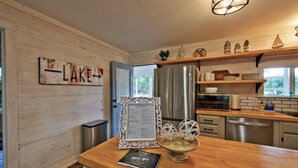 Eine moderne Küche mit Holzausstattung, Edelstahlgeräten und einem rustikalen Schild mit der Aufschrift 'LAKE'.