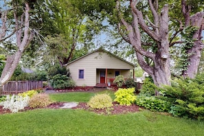 Stroll up to this charming single-story home, surrounded by lush greenery and vibrant flowers.