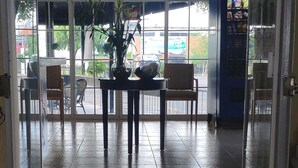 Una entrada con ventilador de techo, puerta de cristal y vista al exterior a través de amplios ventanales.