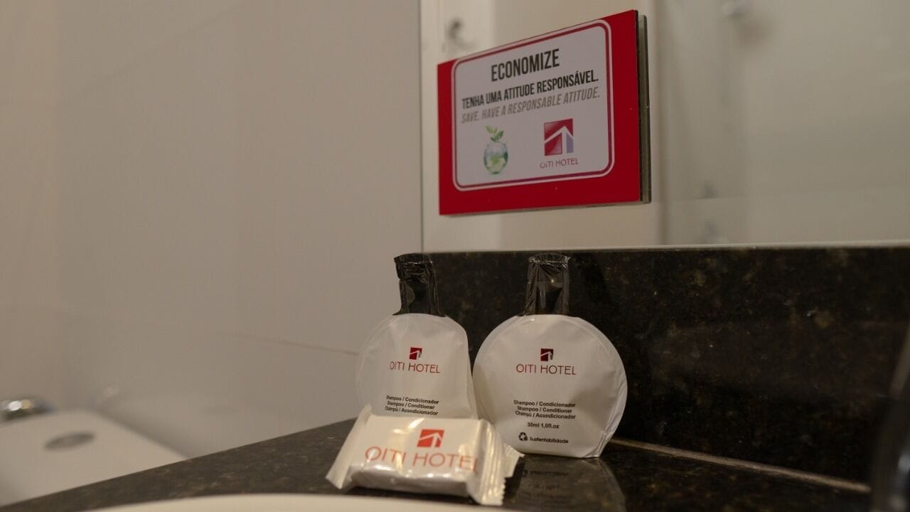 A bathroom counter with two toiletries bags and a sign above them.