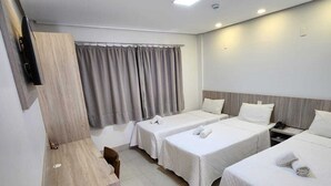 Habitació d'hotel amb dos llits, un escriptori i una televisió.